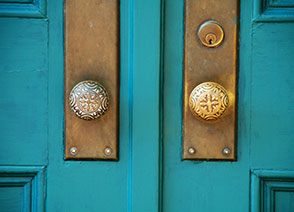 brass hardware on a teal blue door