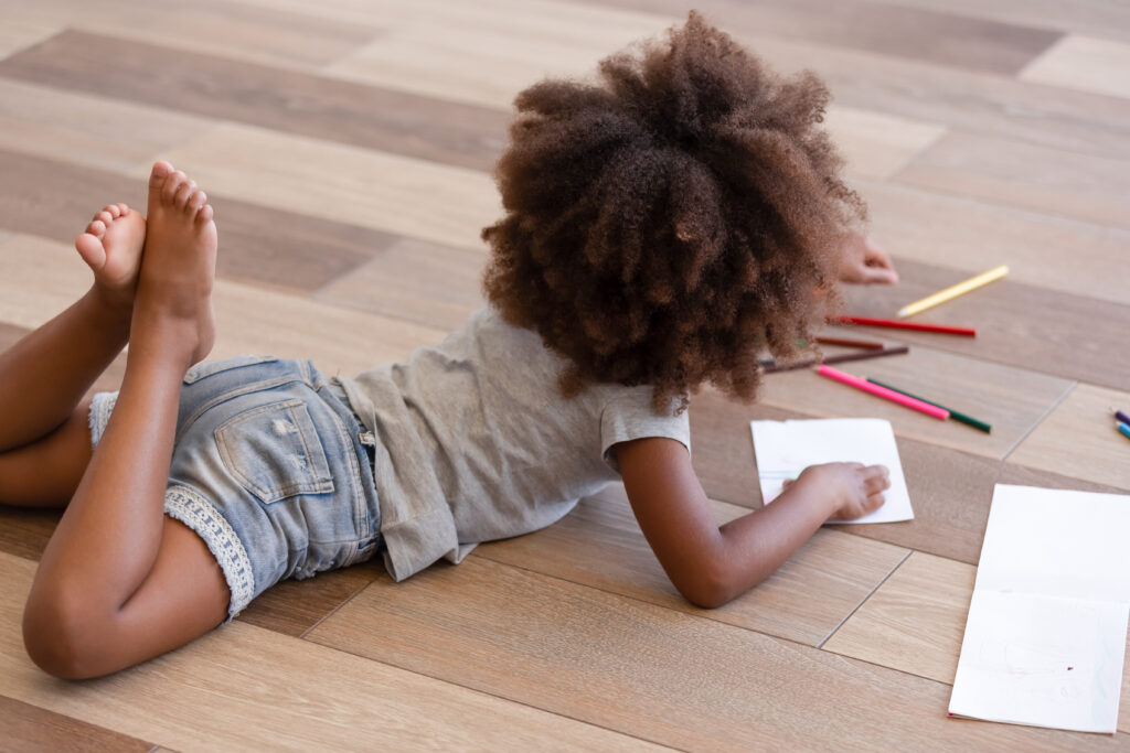 little girl on laminate floor coloring